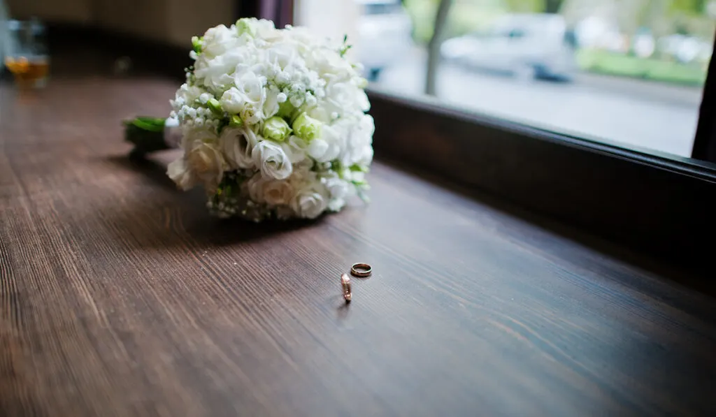 wedding flowers on a wooden table with rings