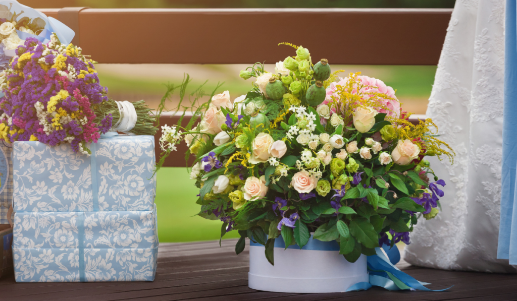 Beautiful bouquet next to wedding gifts outdoors