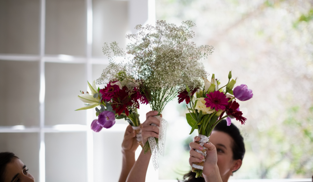 Bride and bridesmaids holding DIY flowers bouquet at home