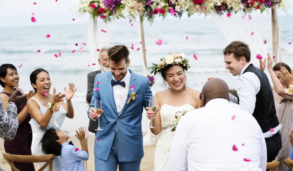 Cheerful newlyweds at beach wedding ceremnoy 