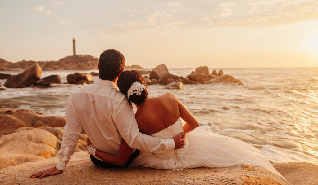 honeymoon newly wed couple relax on sunset beach 