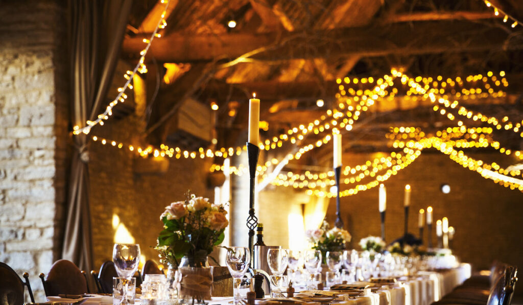 A small wedding venue decorated for a party, with fairy lights and the tables set