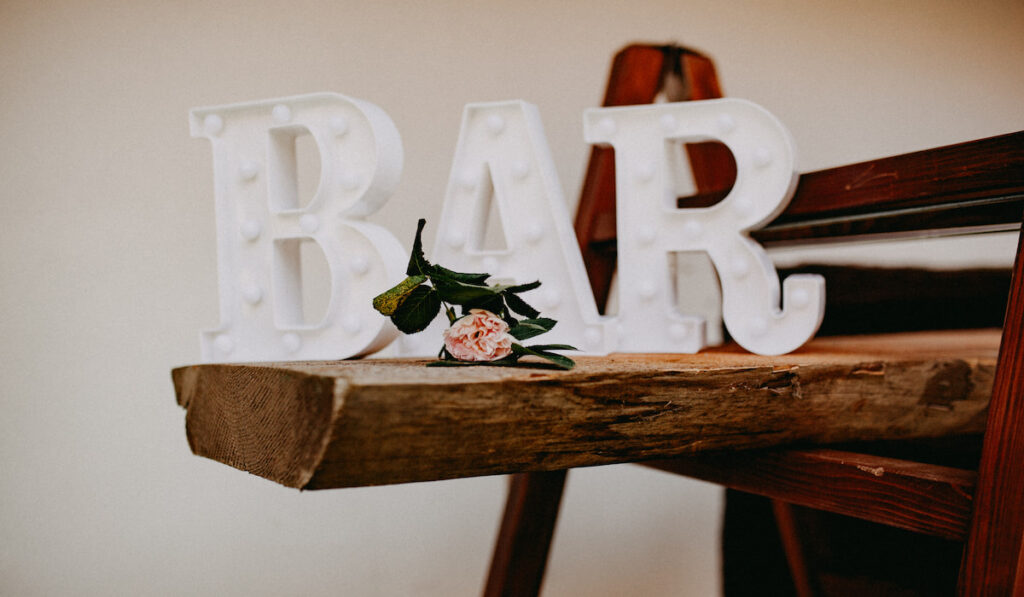 Wedding Bar sign and a flower on wooden log on wedding reception 