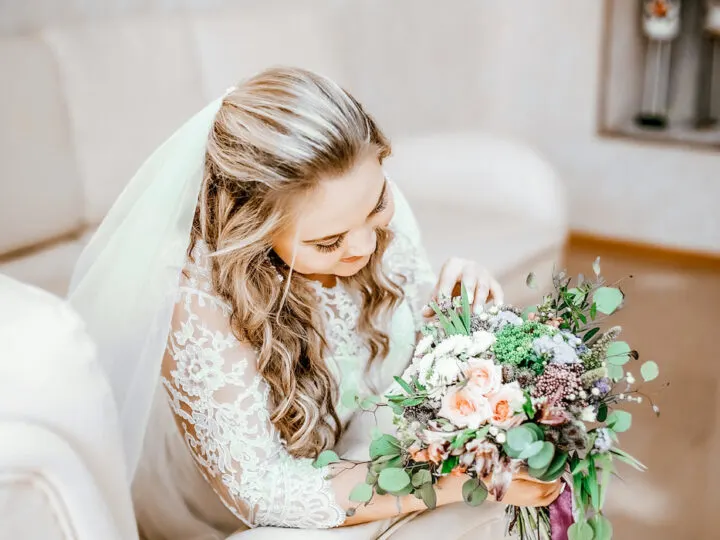 Beautiful-bride-looking-at-her-bridal-bouquet