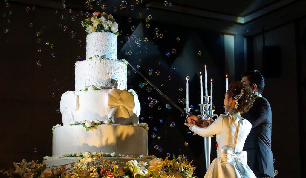 Bride and groom cutting their big wedding cake in wedding reception 