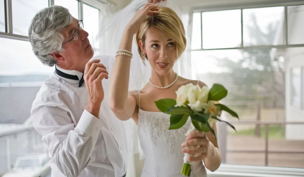 Brie with his father helping her attaching the veil 