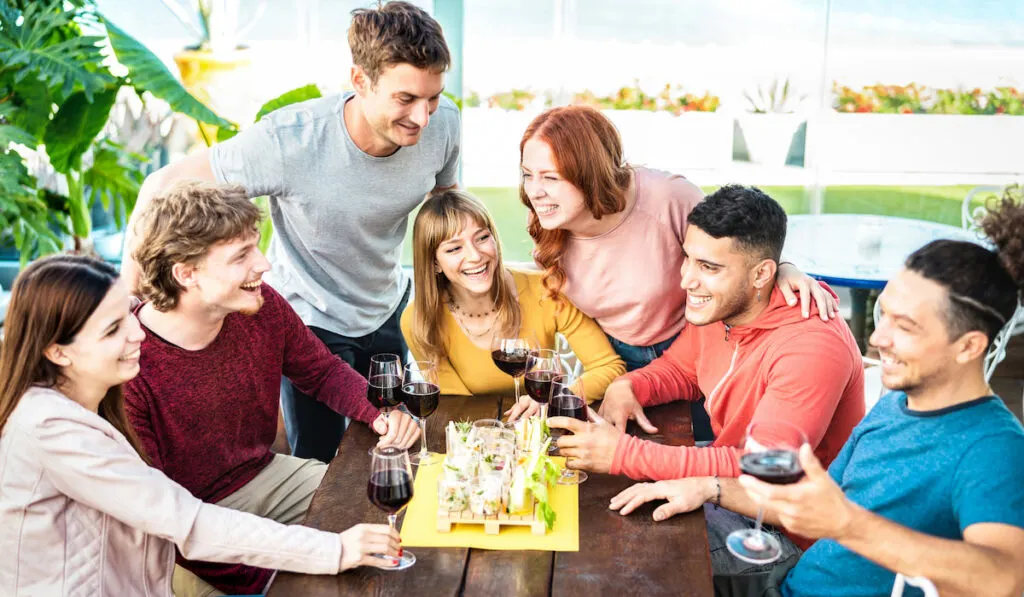 Couple and their friends discussing about wedding plan and drinking wine