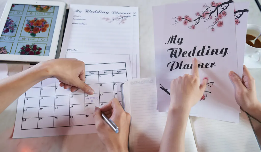Couple choosing date for wedding holding wedding planner