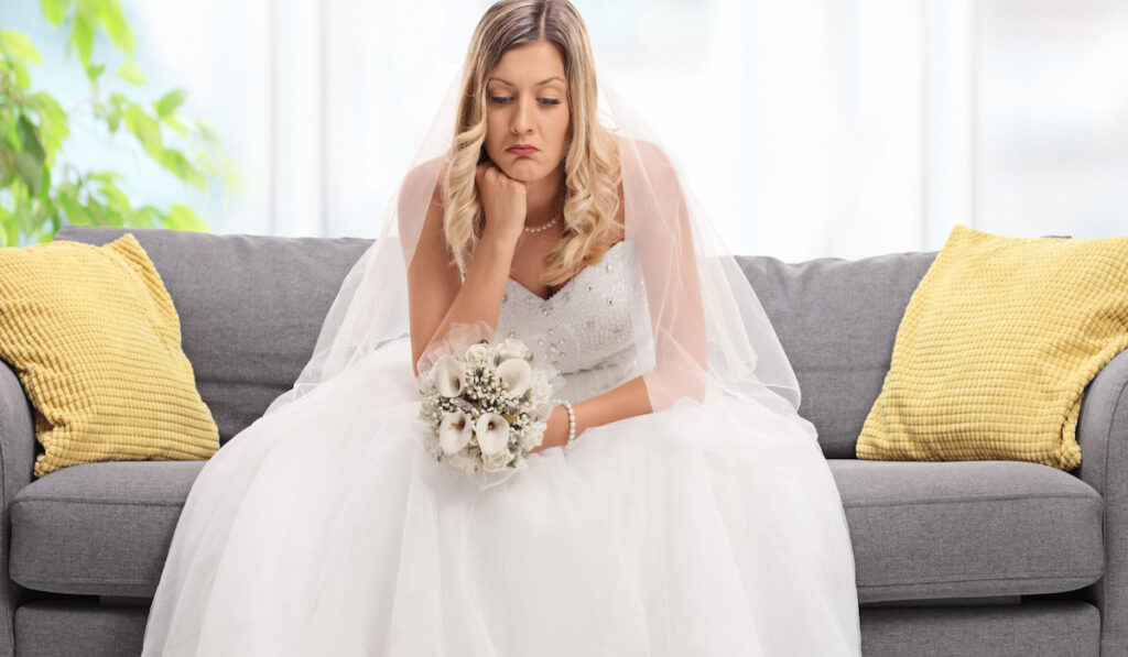 Disappointed bride sitting on the sofa