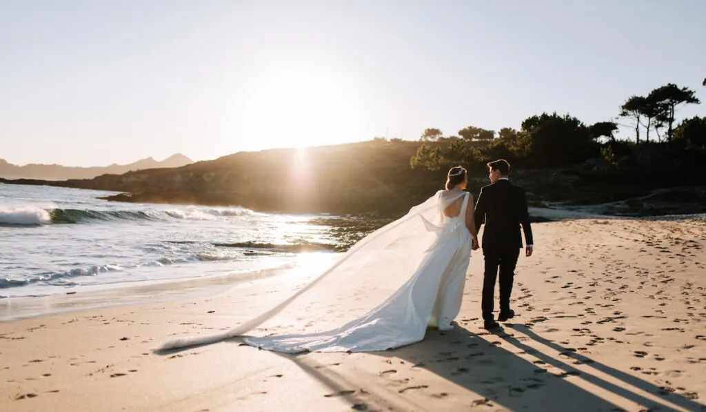 Just married couple walking on a beach, elopement concept