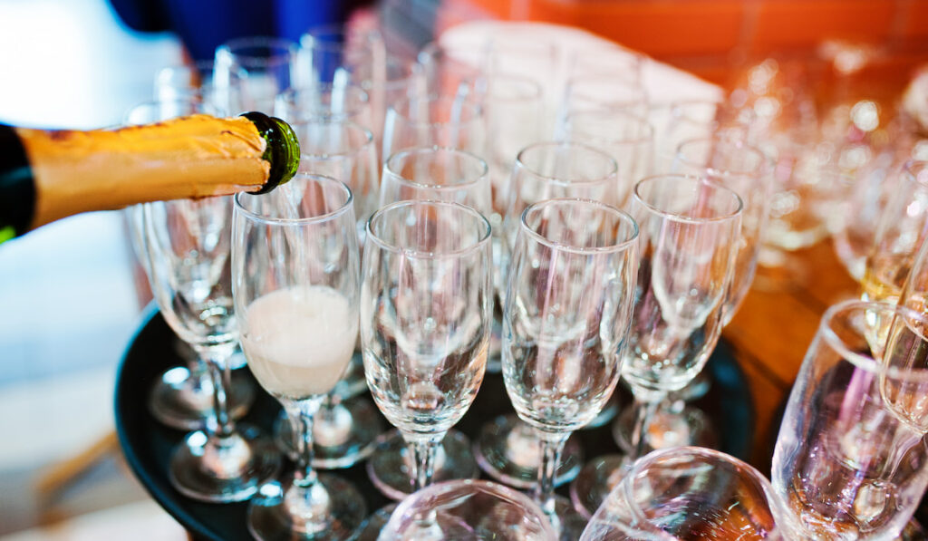Pour champagne into glasses at wedding party
