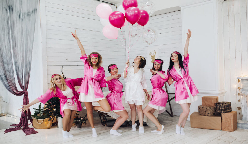 Pretty girls in pink robes and sleep masks with balloons at bridal showers
