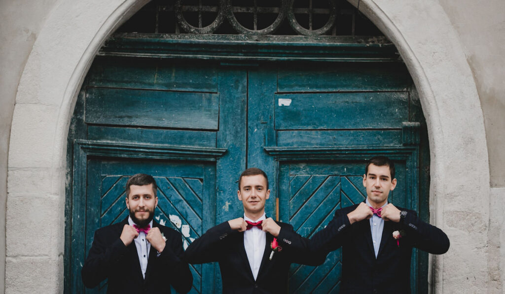 The groom and groomsmen correcting their butterflies 