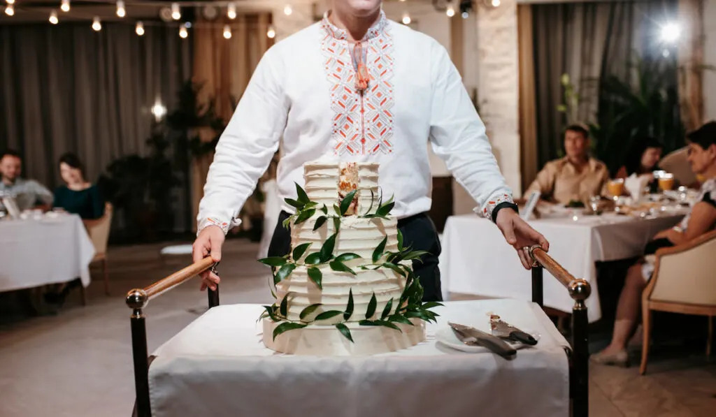 Waiter setting up the wedding cake at wedding reception