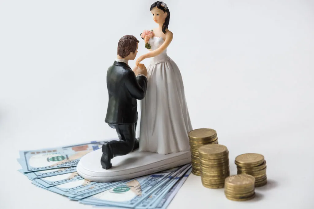 Wedding statuette of groom and bride with coins and dollars on it