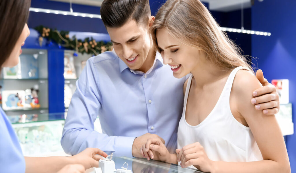Young couple choosing wedding ring in jewelry store 