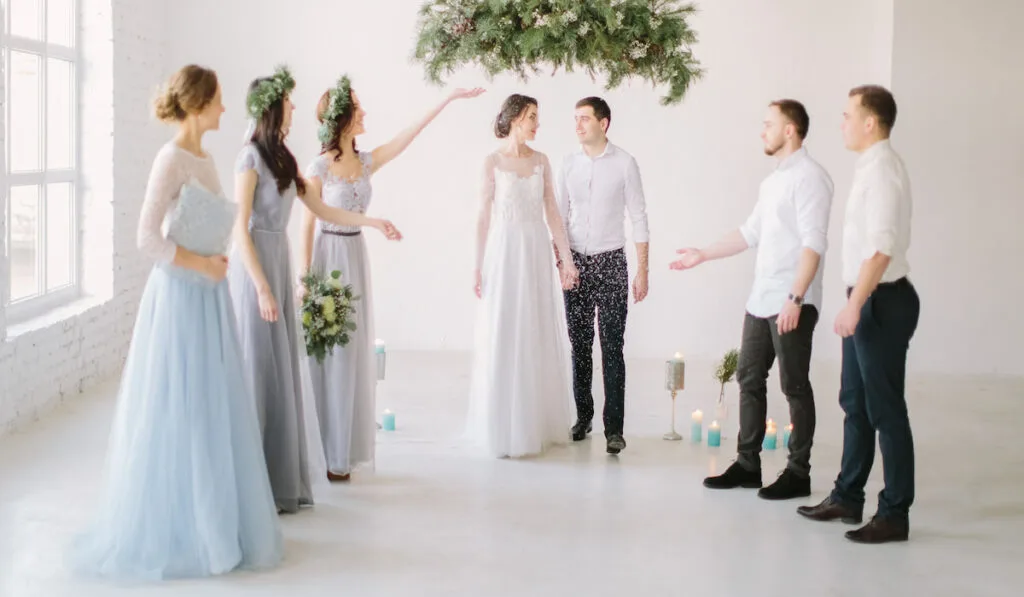 bridesmaid Throwing Confetti Over Bride And Groom At Wedding 