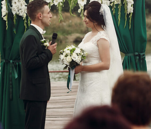 cropped-Beautiful-couple-groom-giving-wedding-vow-at-wedding-ceremony-near-lake-ee220623.jpg