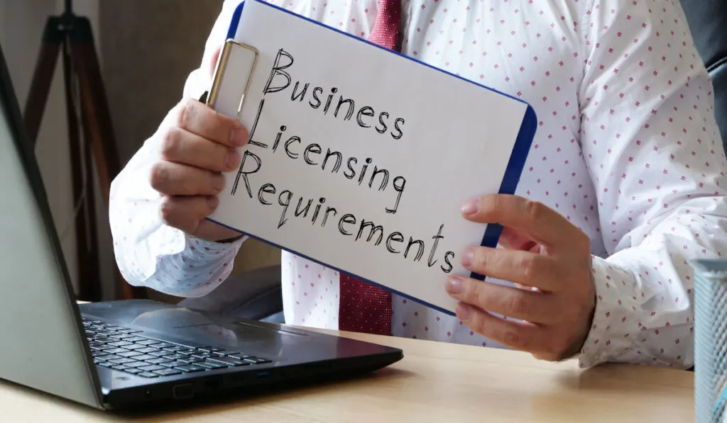 cropped photo of a man holding clipboard indicating business licensing requirements
