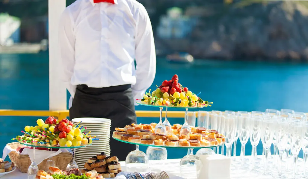 decorated table with fruits and sandwiches on a beach resort party