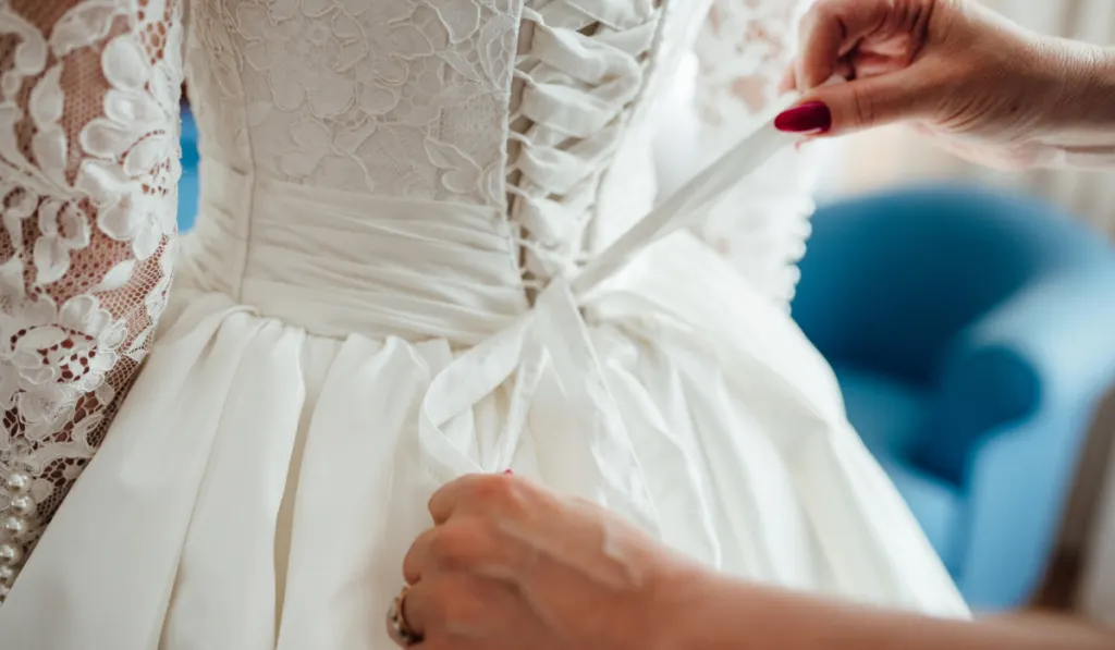 fastening-the-wedding-dress-closeup-on-hands