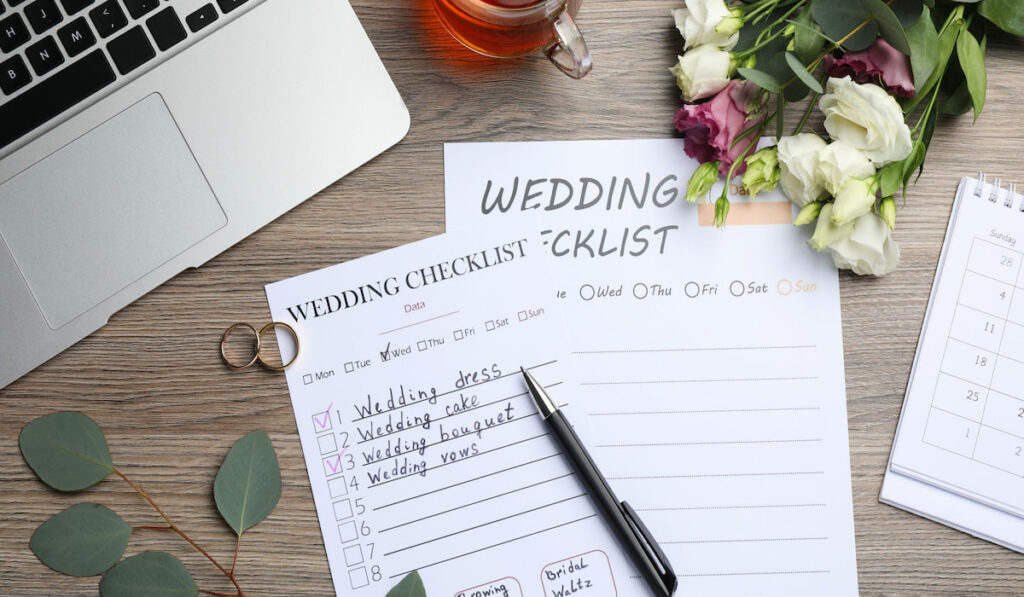flat lay of wedding checklist with a cup of tea and flowers