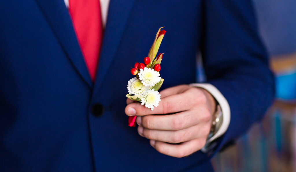 groom holding the boutonniere 