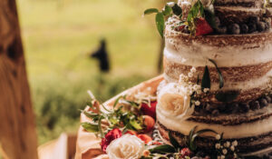 naked wedding cake decorated with flowers and fruits