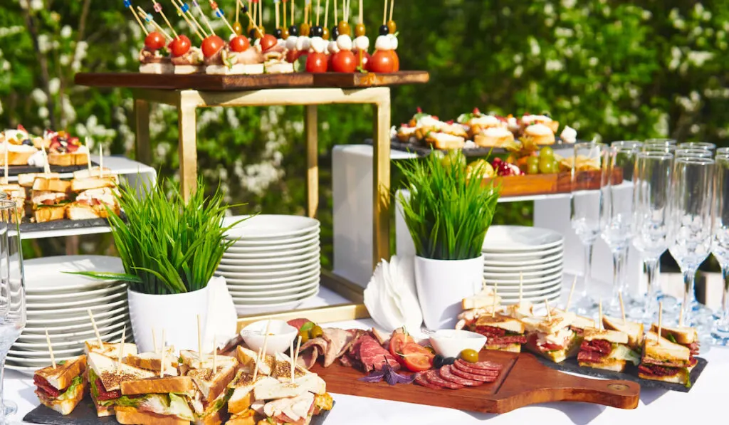 outdoor buffet table with glasses and sandwiches for wedding reception 