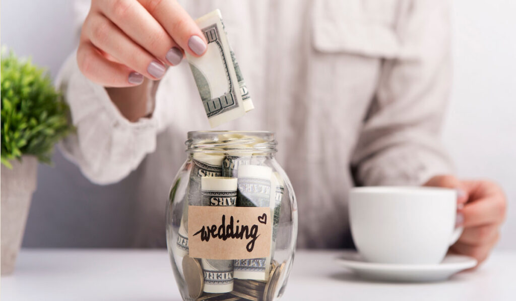 woman putting money savings in a jar for wedding 