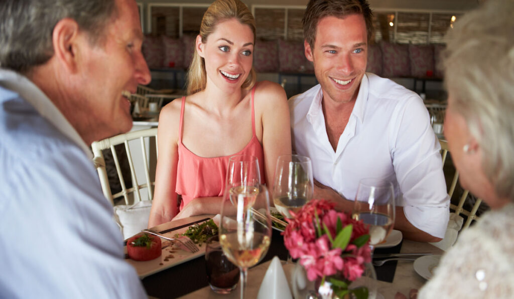 Couple talking to their parents in a restaurant about wedding plan 