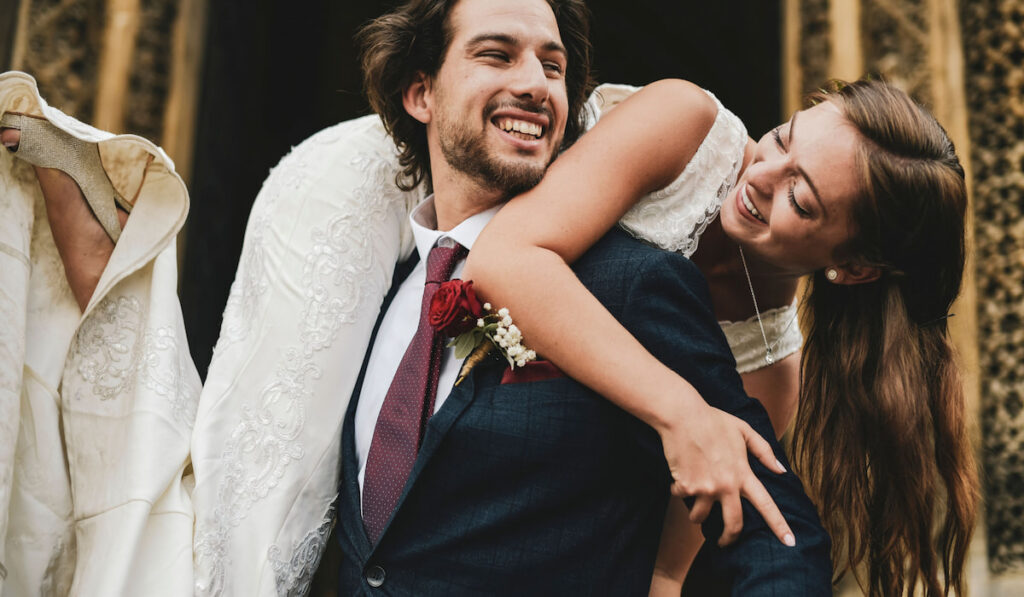 Groom lifting up his beautiful bride as wedding exit -