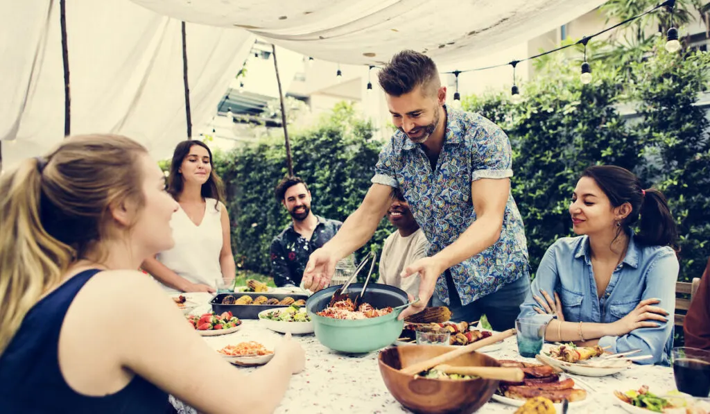 Group of friends enjoying summer party together pot luck concept