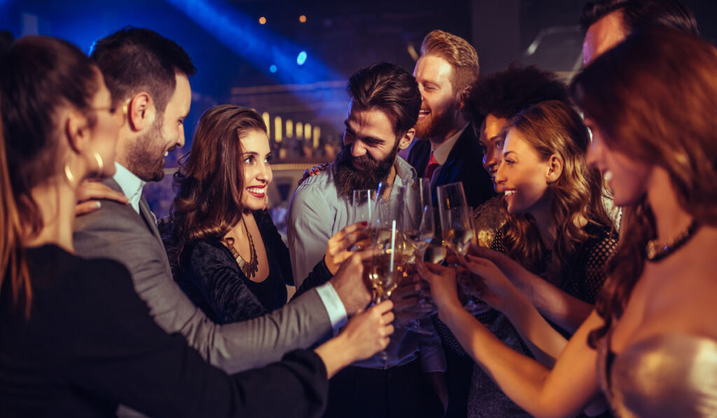 Group of friends toasting for newlyweds, wedding after party concept 