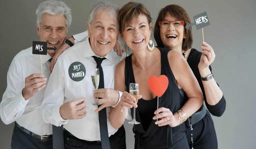Senior couples posing with props for wedding photo booth 