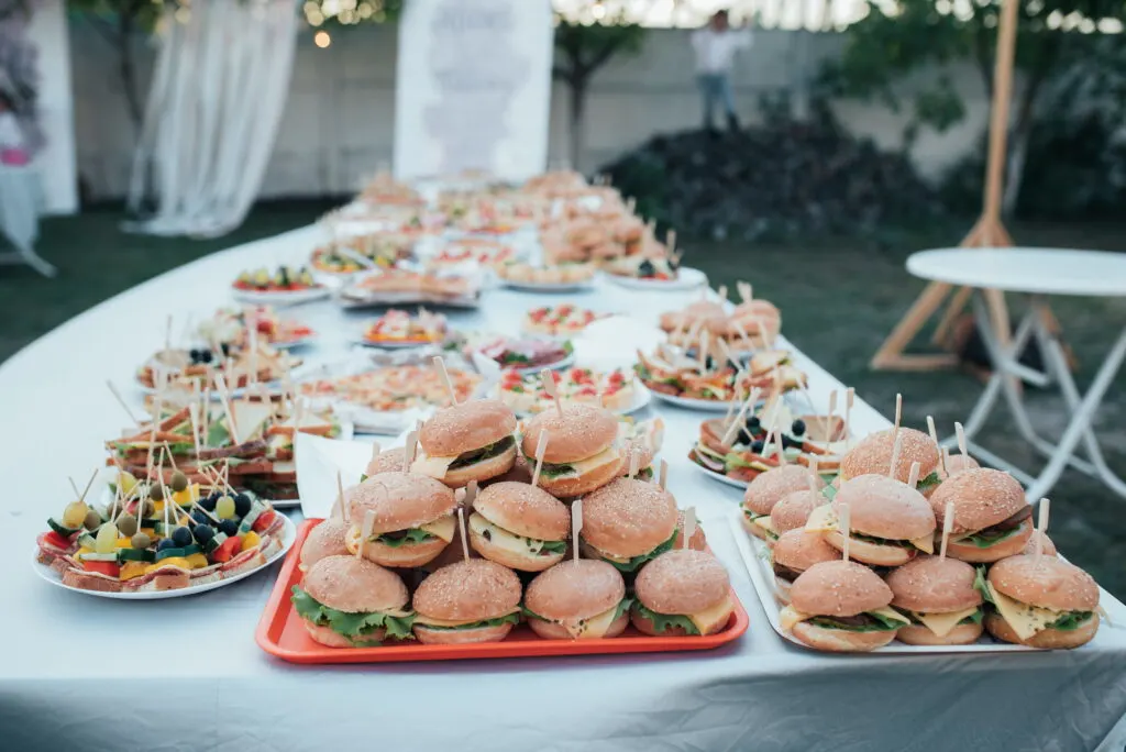 Wedding buffet with various snacks and burgers in nature.