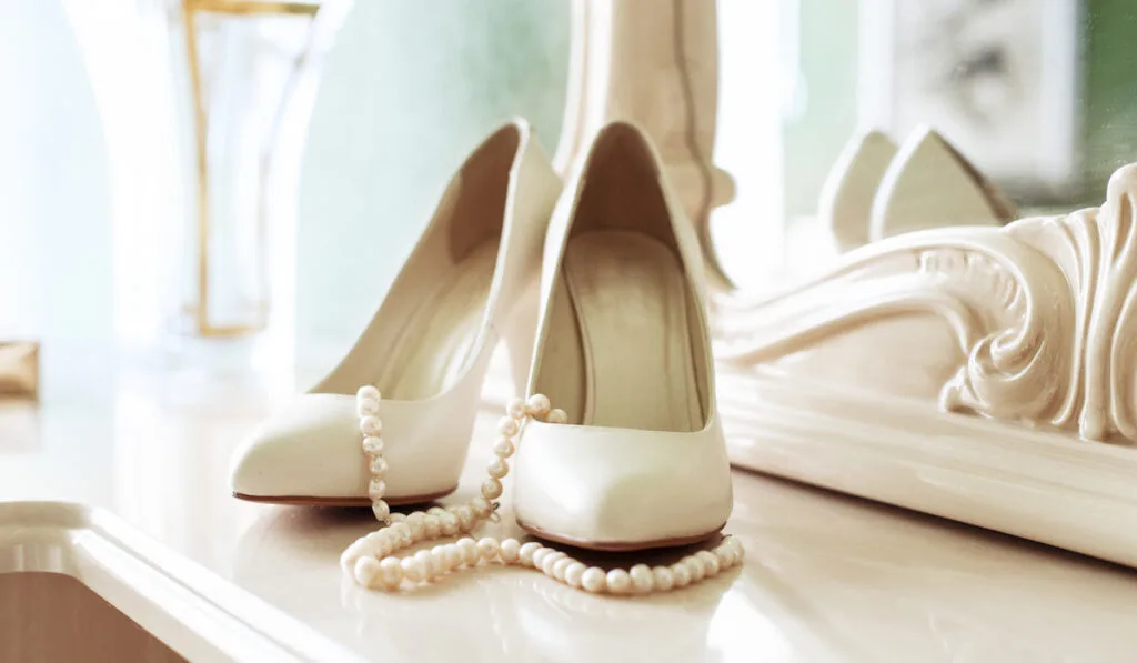White wedding shoes and pearl necklace