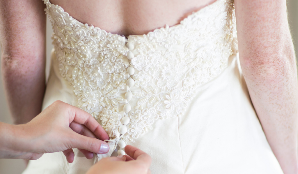 buttoning up bride's wedding dress