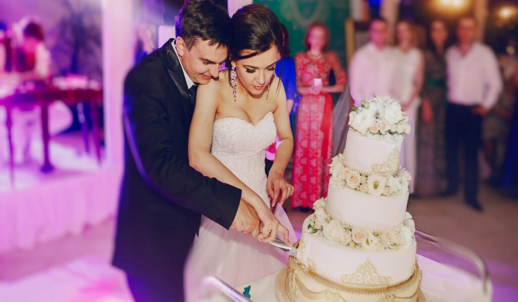 groom with bride cutting the cake at their wedding 