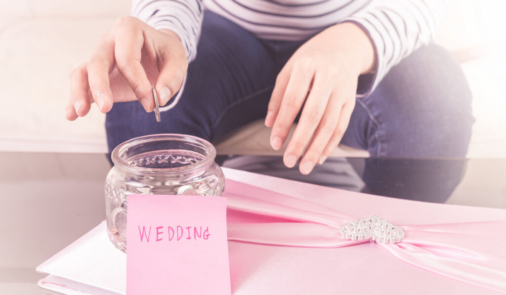 hang putting coins in jar with money for wedding, wedding budget concept