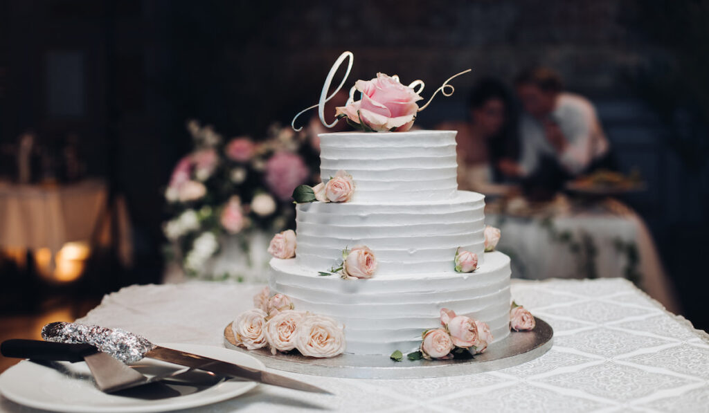 Beautiful wedding cake with flowers on table
