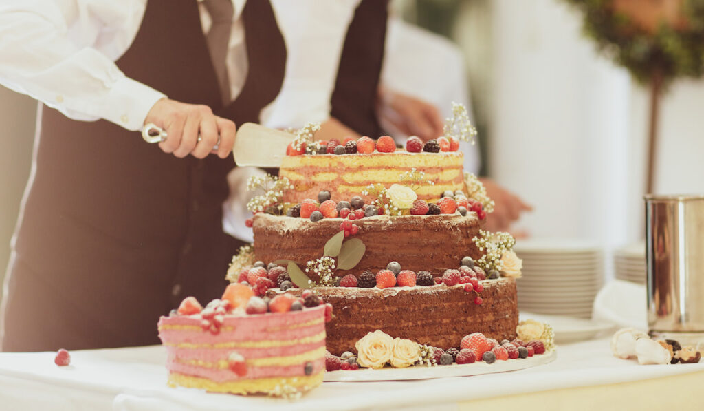The waiter cuts the wedding cake
