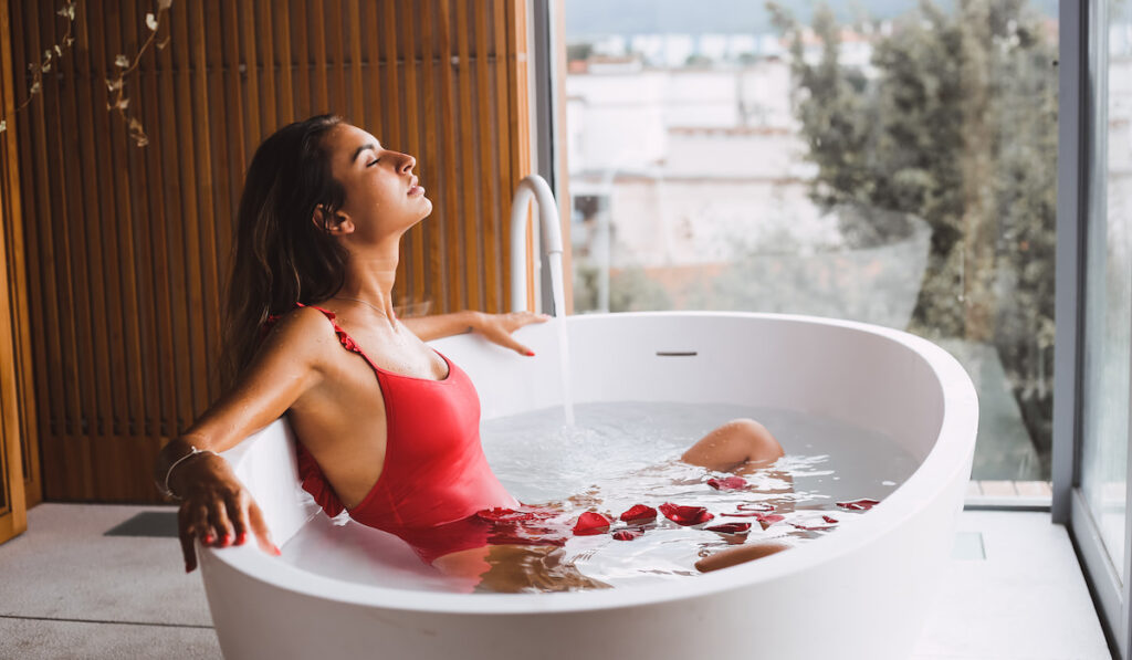Woman bathing and relaxing in a modern bath tub

