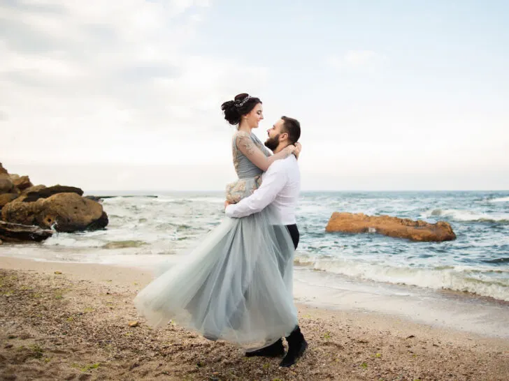 newly-wed-having-fun-by-the-sea-beach-wedding-concept-bride-wearing-light-blue-wedding-dress