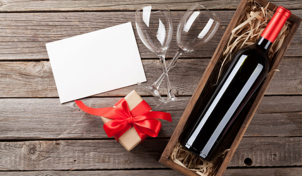 Wine and gift box on wooden table.
