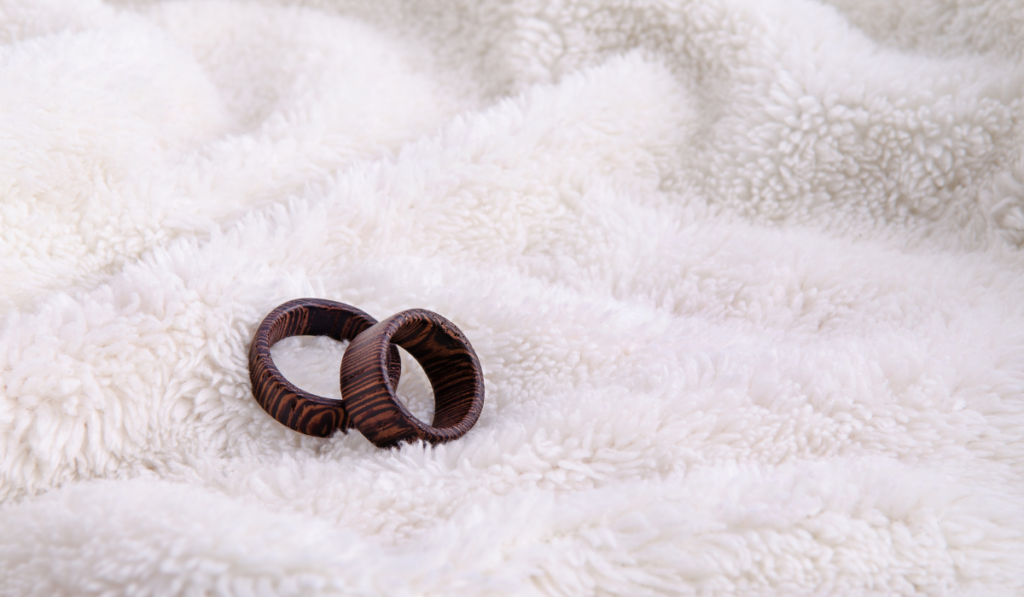 Two striped wooden rings on white fur background
