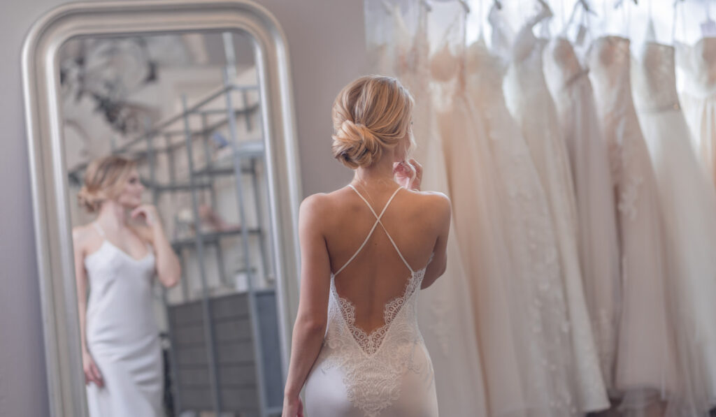 bride fitting wedding dress in a wedding shop