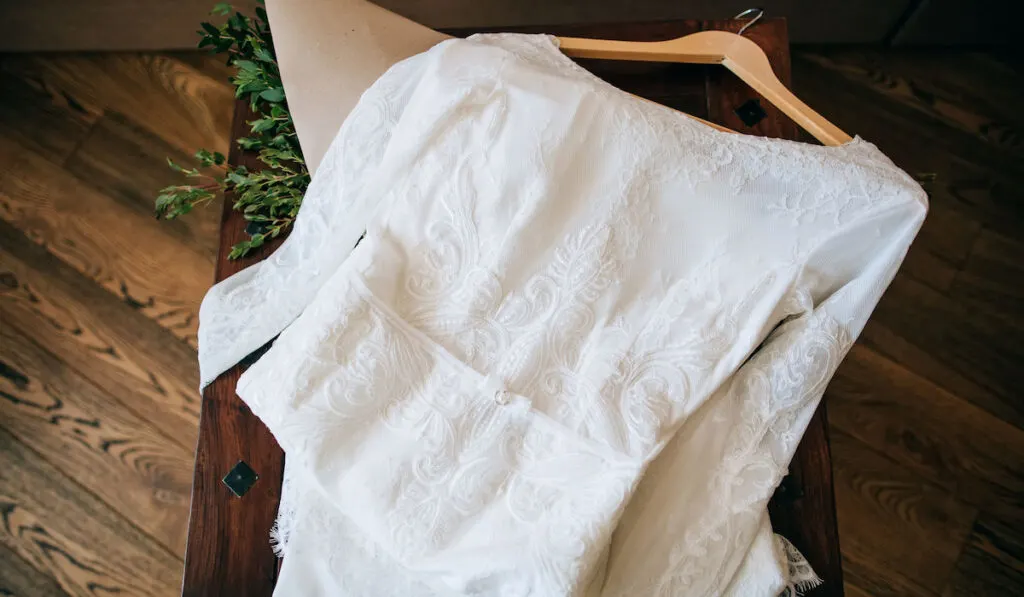 vintage wedding dress with lace on an old wooden rustic table

