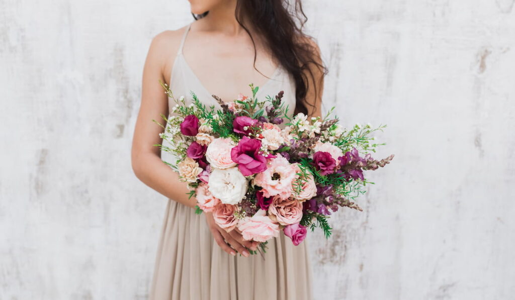Сhic wedding bouquet of peonies and roses in hands of the bride