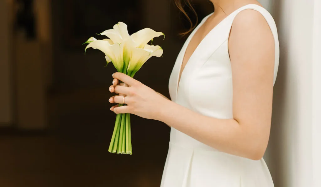 Bride holding beautiful white bouquet of calla lilies 